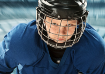 child hockey player wearing helmet and looking into the camera