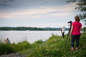 Trois personnes prennent des photos au bord de la rivière