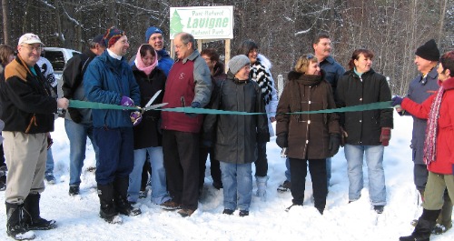 Group of people cutting a ribbon in a forest