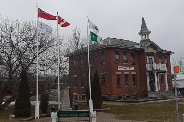 Drapeau de l'autisme qui flotte devant l'hôtel de ville de Clarence-Rockland avec les drapeaux de l'Ontario, du Canada, de Clarence-Rockland et Franco-ontarien