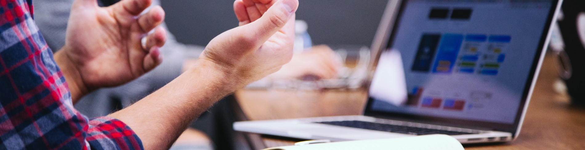 Person gesturing in front of computer