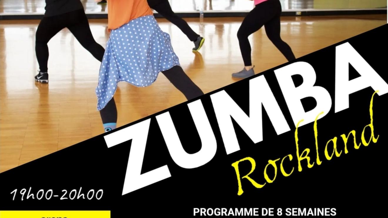 Zumba class with participants dancing energetically in a studio setting.