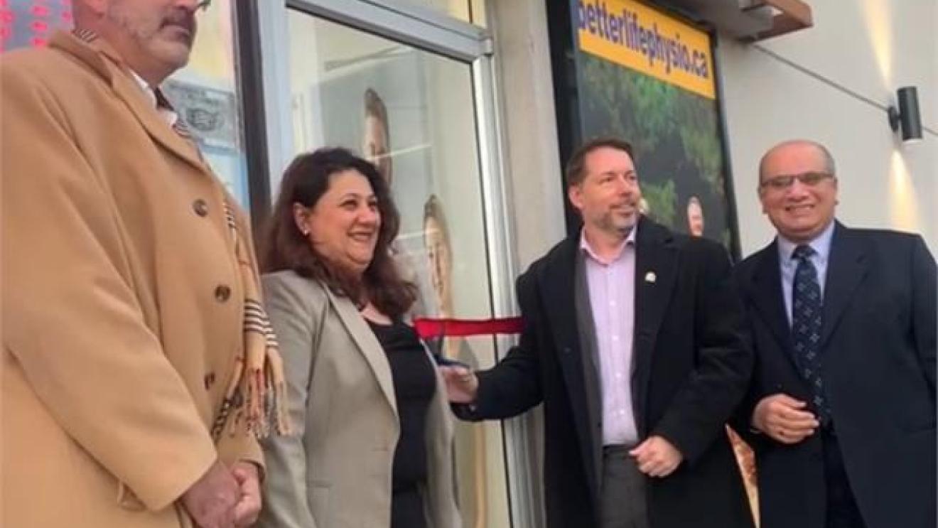 Group of four people at a ribbon-cutting ceremony outdoors.
