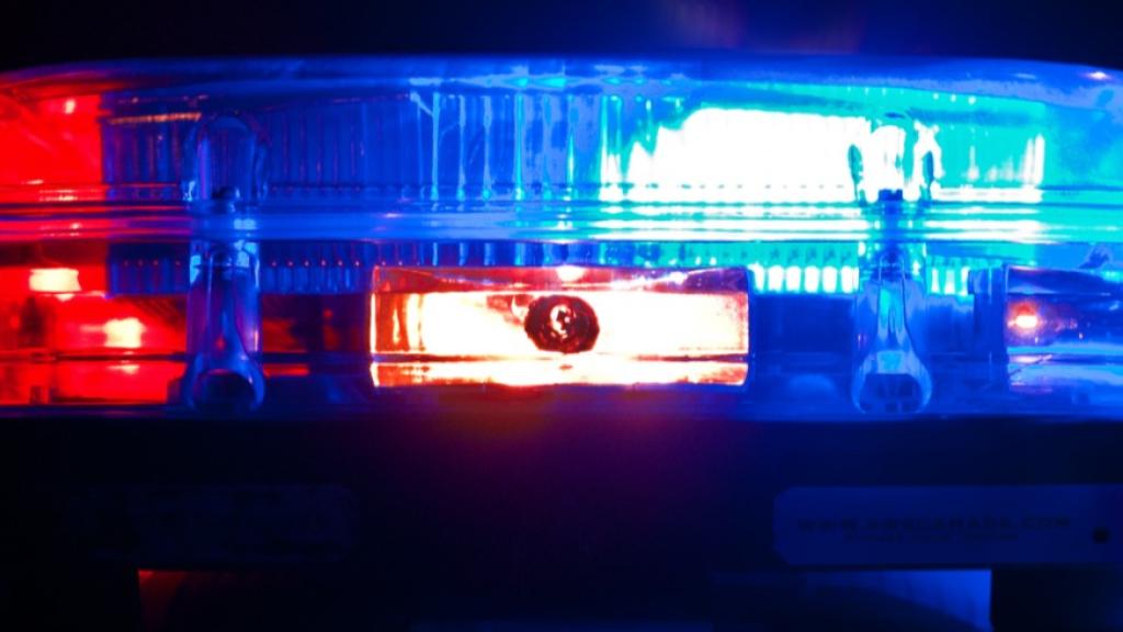 Red and blue police lights flashing against a dark background.