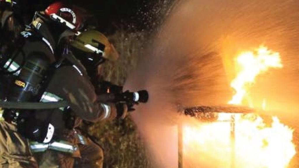 Firefighters extinguishing a blaze at night.