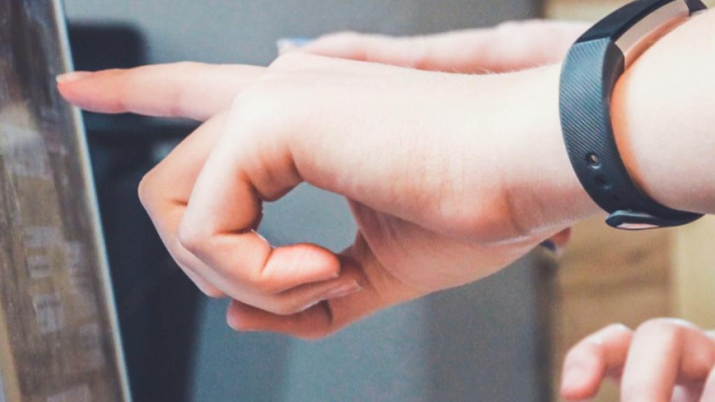 Hands pointing at a computer screen.