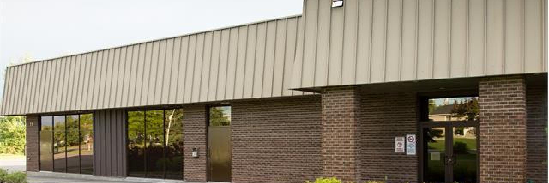 Single-story brick building with large windows and a metal roof.
