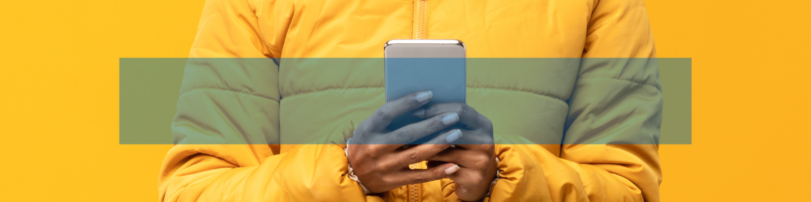 Person in yellow jacket holding smartphone, yellow background.